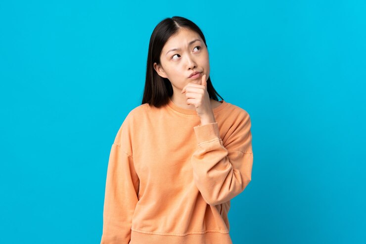 Photo 疑問を持つ孤立した青の若い中国人の女の子