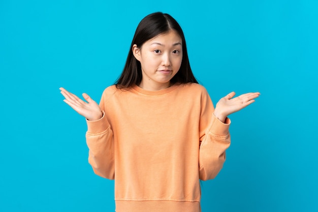 Young Chinese girl isolated making doubts gesture