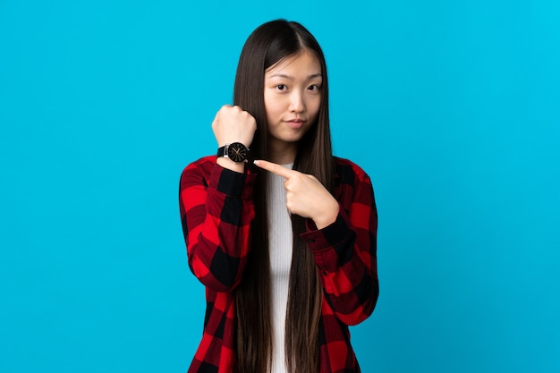 Young Chinese girl over isolated making the gesture of being late