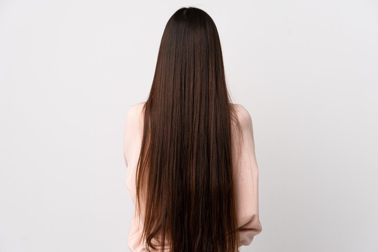 Photo young chinese girl over isolated white wall in back position