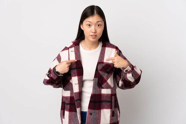 Young Chinese girl over isolated white wall pointing to oneself