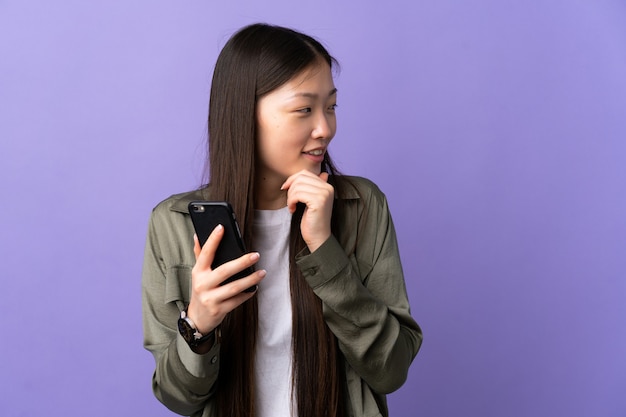 Giovane ragazza cinese utilizzando il telefono cellulare isolato