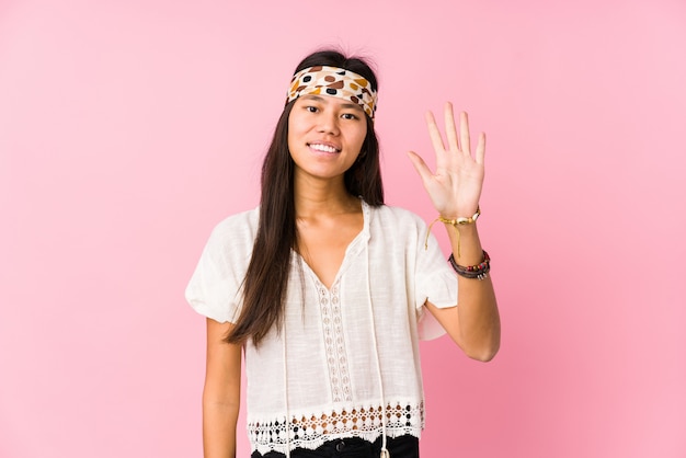 Young chinese hippie smiling cheerful showing number five with fingers.