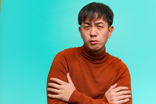 Young chinese man crossing arms relaxed