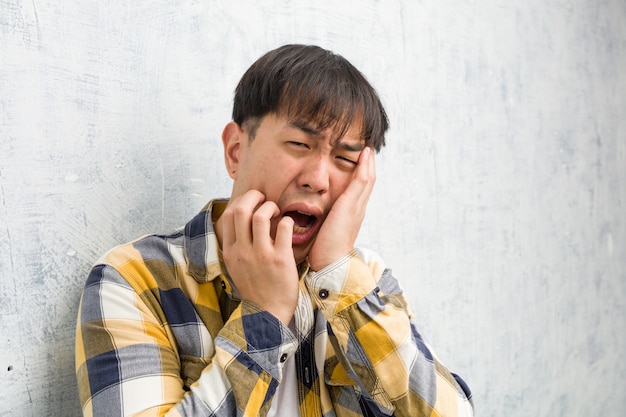 Young chinese man face closeup desperate and sad