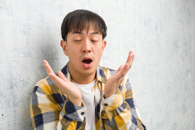 Young chinese man face closeup surprised and shocked