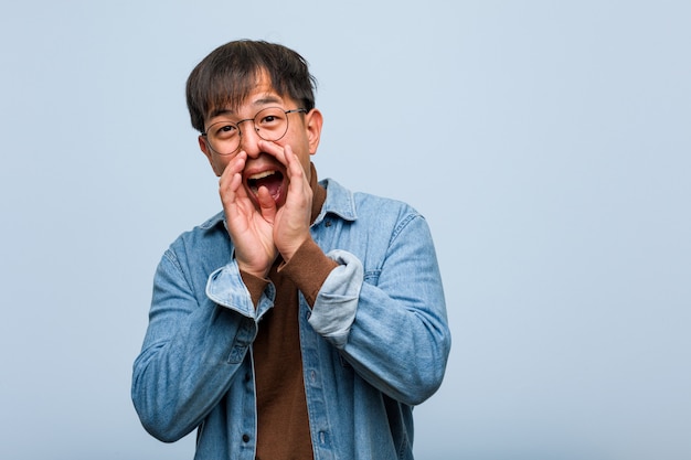 Young chinese man shouting something happy to the front