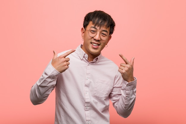 Photo young chinese man smiles and pointing himself