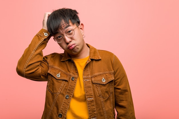 Young chinese man wearing a jacket worried and overwhelmed