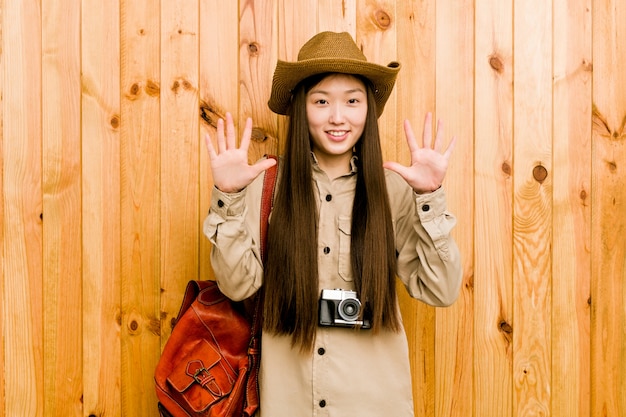 Young chinese traveler woman showing number ten with hands.