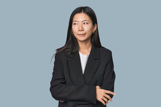 Young Chinese woman in business suit confused feels doubtful and unsure