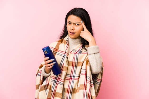 Young chinese woman doing a camping isolated on pink background pointing with finger at you as if inviting come closer.