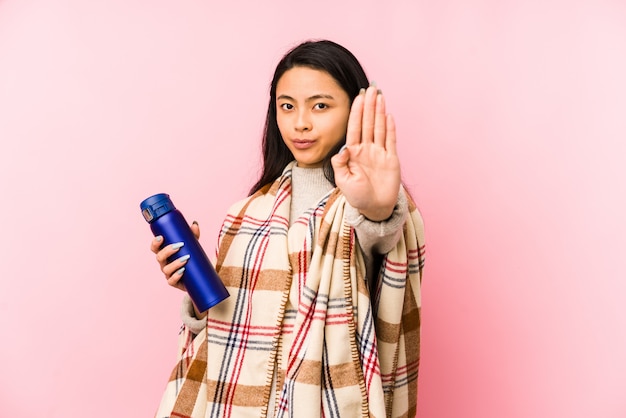 Young chinese woman doing a camping isolated on pink wall confused, feels doubtful and unsure.