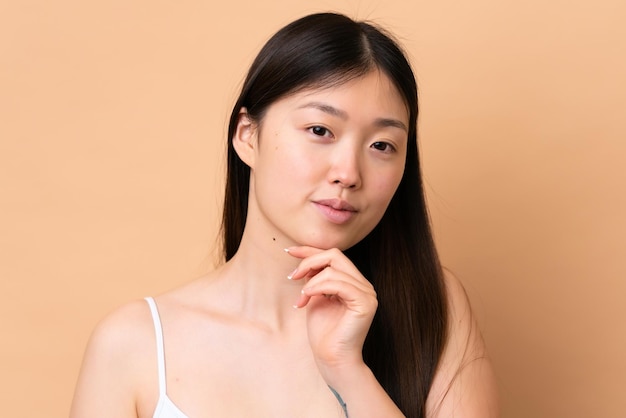 Young Chinese woman isolated on beige background Portrait