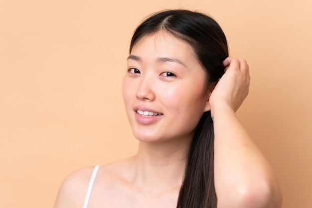 Photo young chinese woman isolated on beige background portrait