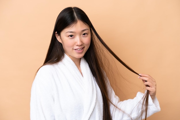 Young chinese woman isolated on beige background portrait