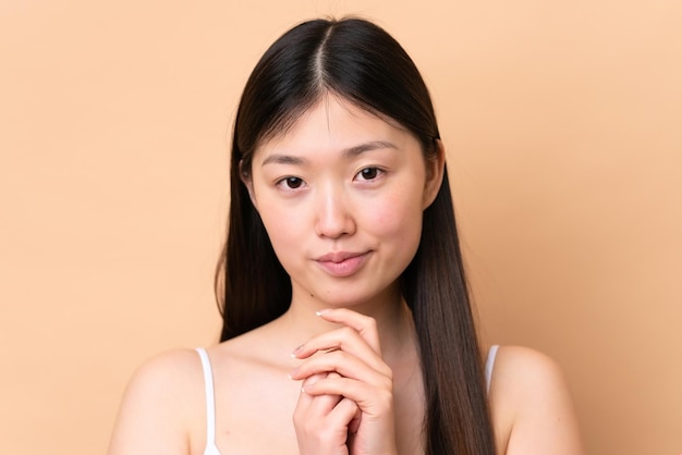 Photo young chinese woman isolated on beige background portrait