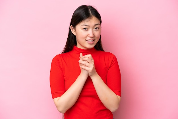 Young Chinese woman isolated on pink background laughing