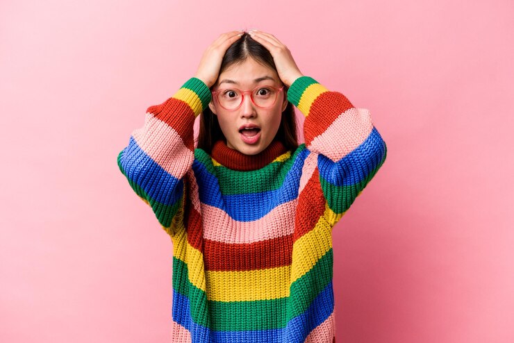 Photo 분홍색 배경에 격리된 젊은 중국 여성이 놀라고 충격을 받았습니다.
