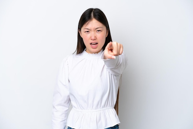 Young Chinese woman isolated on white background frustrated and pointing to the front