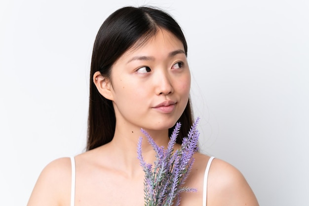 Young Chinese woman isolated on white background holding a lavender plant Close up portrait