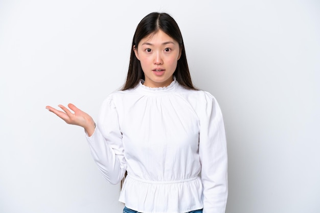 Young Chinese woman isolated on white background making doubts gesture