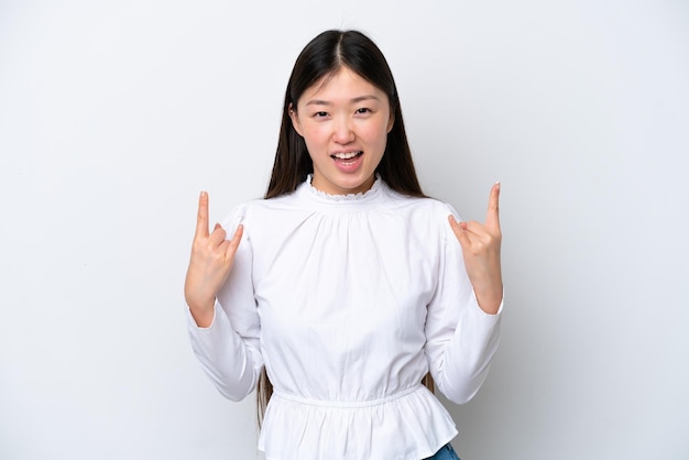 Young Chinese woman isolated on white background making horn gesture