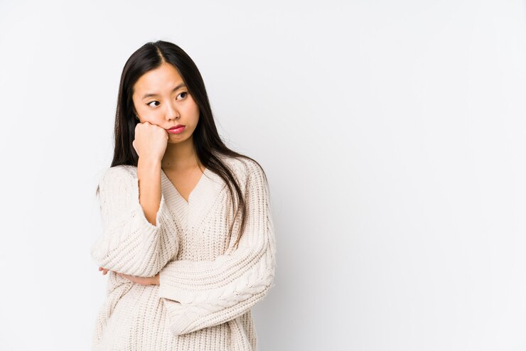 Photo コピースペースを見て悲しいと物思いにふける感じの分離した若い中国人女性。