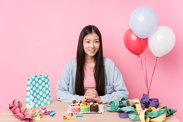 Young chinese woman organizing a birthday isolated happy, smiling and cheerful.