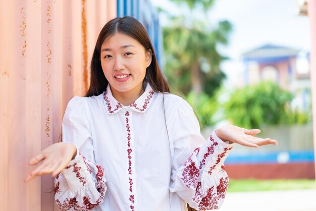 Young Chinese woman at outdoors smiling