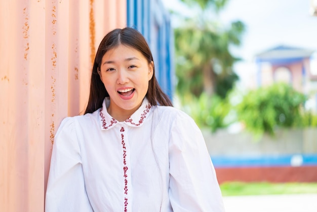 Young Chinese woman at outdoors with surprise facial expression