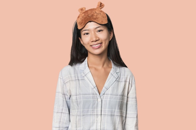 Young Chinese woman in pajamas mask happy smiling and cheerful