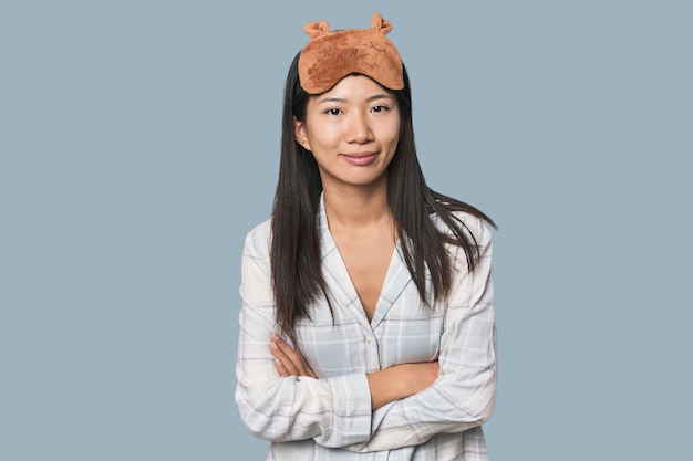 Young Chinese woman in pajamas mask laughing and having fun