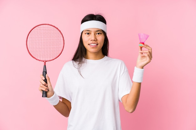 Young chinese woman playing badminton isolated