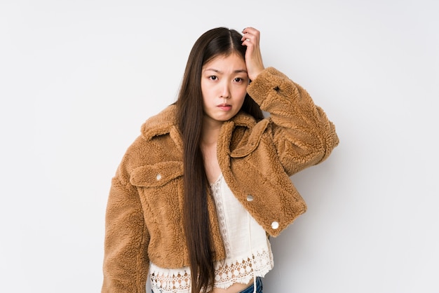 Young chinese woman posing in a white wall isolated being shocked, she has remembered important meeting.