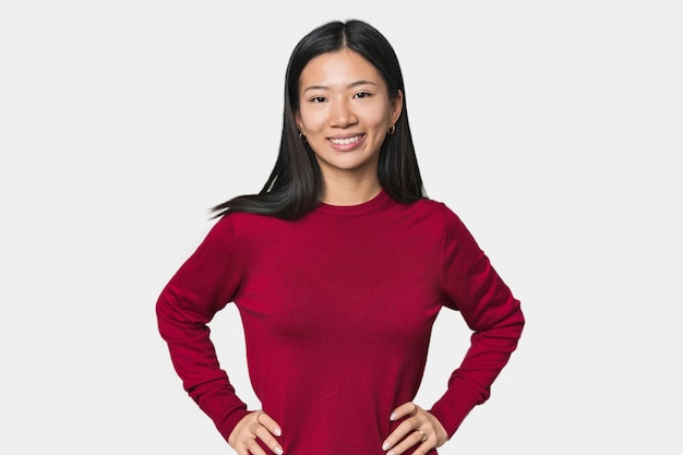 Young Chinese woman in studio setting confident keeping hands on hips
