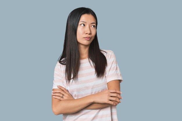 Young Chinese woman in studio setting dreaming of achieving goals and purposes