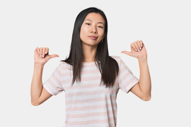 Young Chinese woman in studio setting feels proud and self confident example to follow