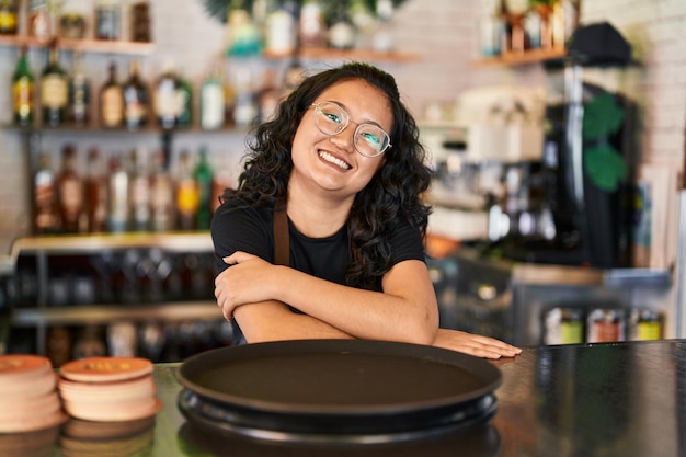 젊은 중국 여성 웨이트리스 레스토랑에서 카운터에 기대어 자신감 미소