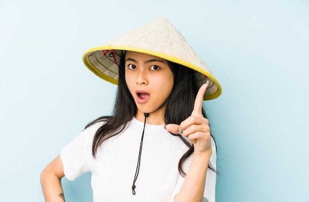 Young chinese woman wearing a vietnamese hay smiling cheerful showing number five with fingers.