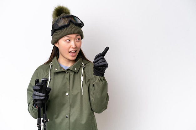 Young Chinese woman wearing winter jacket isolated on white background intending to realizes the solution while lifting a finger up