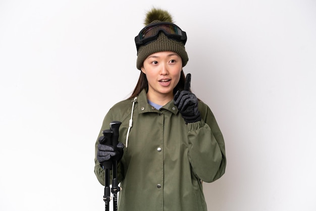 Young Chinese woman wearing winter jacket isolated on white background thinking an idea pointing the finger up