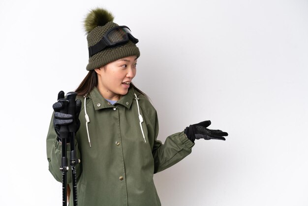 Young Chinese woman wearing winter jacket isolated on white background with surprise expression while looking side