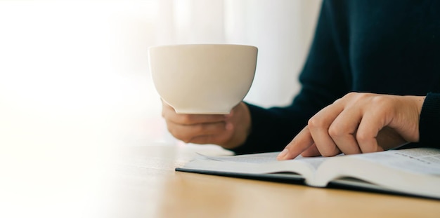 A young Christian woman sits at home reading and studying the Bible on Sundays with her morning