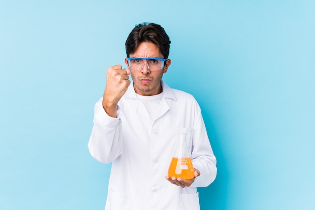 Young cientific caucasian man isolated showing fist to camera, aggressive facial expression.