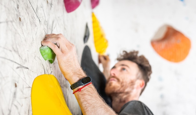 Foto giovane scalatore che si arrampica sul concetto di vista posteriore interna della parete di boulder di sport estremi e bouldering