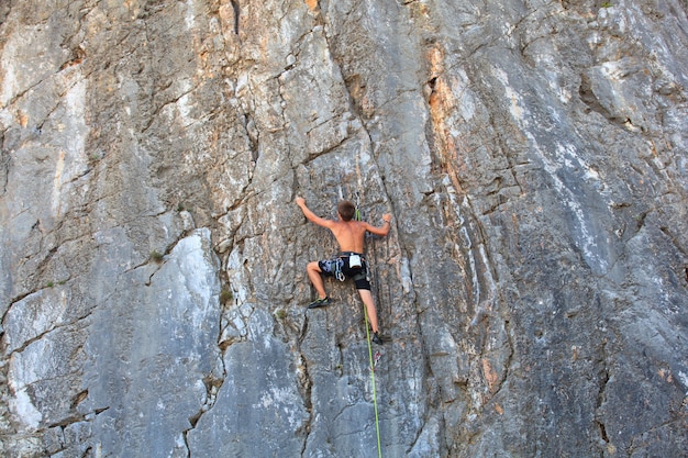 Young climber climbing on Sistiana rock, Trieste