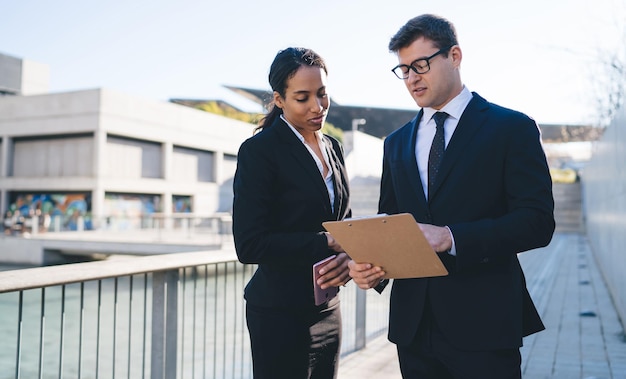 Young collaborating diverse people with clipboard