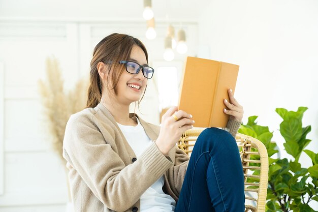 Young collage student reading a book sitting in a chairxA