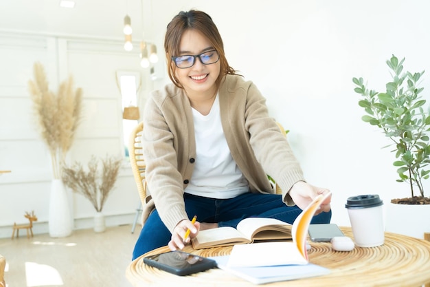 椅子に座って本を読んでいる若いコラージュ学生xA